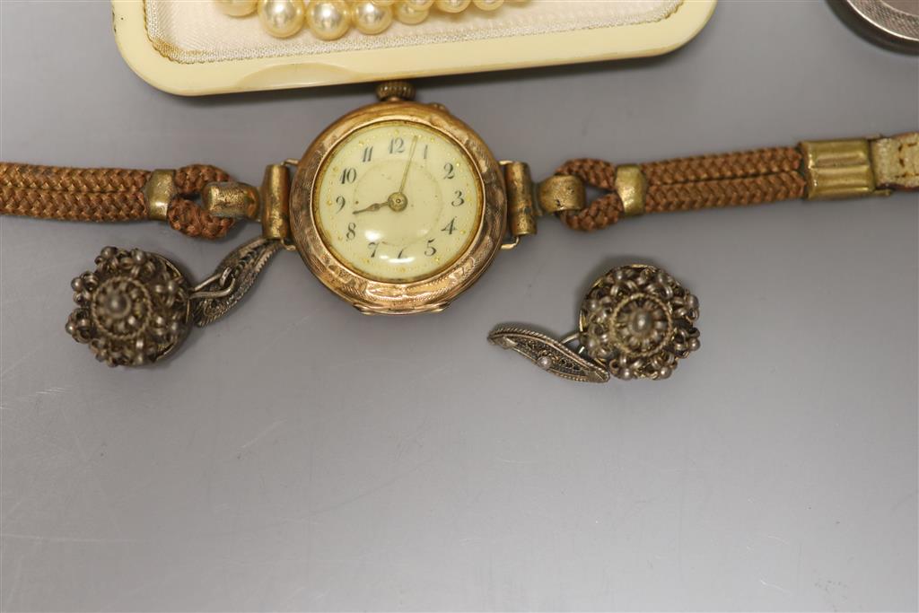 A ladys 585 yellow metal manual wind wrist watch, gross 23.2 grams, a white metal locket and other minor jewellery.